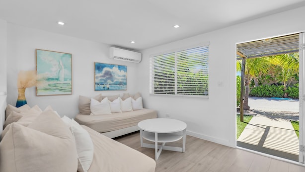 A modern living room with a sofa, a round table, and two paintings on the wall. - 3. Waterfront Key Largo Studio | Scuba & Dock (Key Largo)