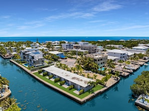 A coastal residential area with modern buildings, a marina, and a clear view of the ocean. - 3. Waterfront Key Largo Studio | Scuba & Dock (Key Largo)