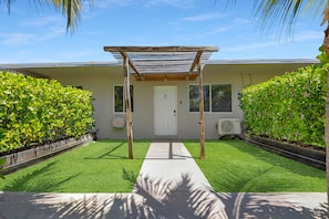 A covered outdoor area with a concrete path leading to a building entrance. - 3. Waterfront Key Largo Studio | Scuba & Dock (Key Largo)