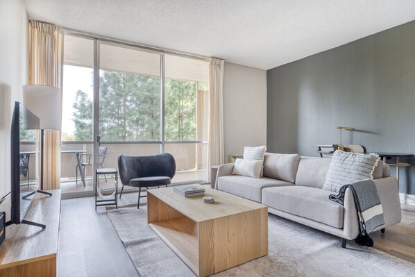 Relax in this stylish living room with a sofa, chair, and flat-screen TV.