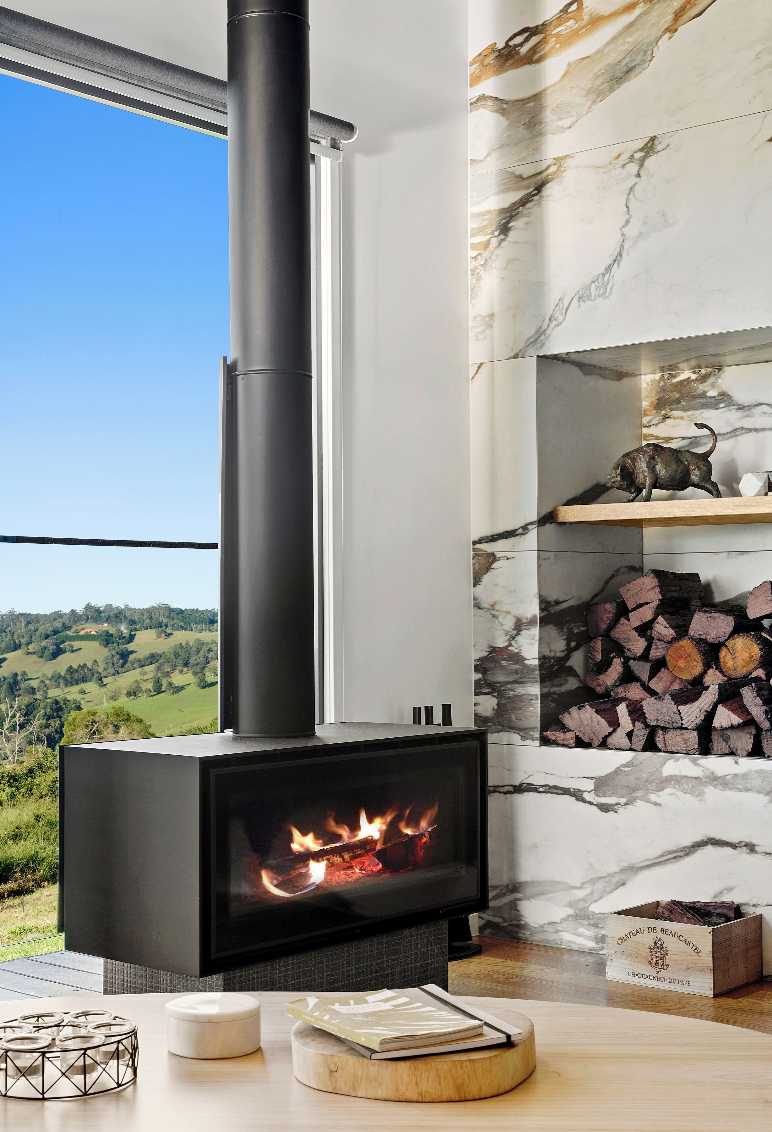 A modern fireplace with a clear view of the countryside.