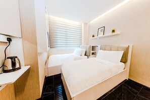 A modern hotel room with a large bed, a smaller sofa, a kettle on a shelf, and a window with blinds. - D'nova Hotel @ Bugis (Singapore)