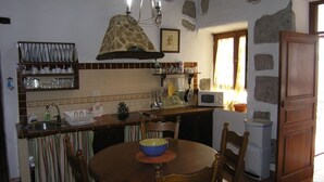 A kitchen with a dining table, chairs, a microwave, and a sink.