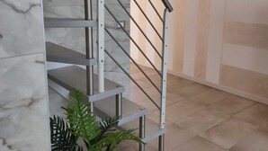 A modern staircase with metal railings and marble walls. - Casa Viola: Your Relaxing Retreat by the Lake (Pacengo)