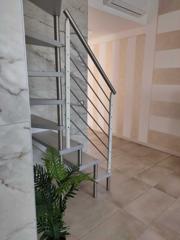 A modern staircase with metal railings and marble walls. - Casa Viola: Your Relaxing Retreat by the Lake (Pacengo)