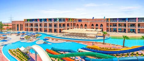 A hotel with multiple swimming pools, water slides, and a large building with balconies.