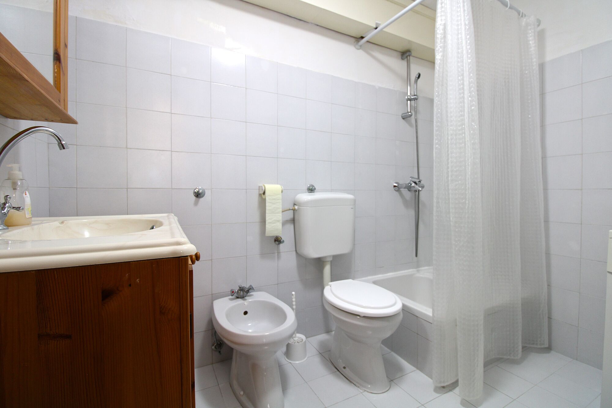 Une salle de bain équipée d’un lavabo, d’un bidet, de toilettes et d’une baignoire.