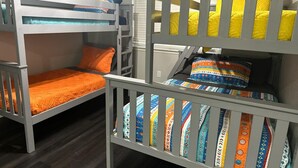 Dormitorio con literas, dos camas, colchones y almohadas.