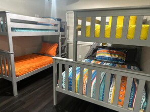 Une chambre avec un lit superposé, comportant deux lits, chacun avec un matelas et des oreillers.