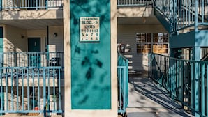 Un edificio de varios pisos con un cartel que indica Champions Bldg. - 5 unidades, numeradas 910, 1112, 567, 678, 123, 134.