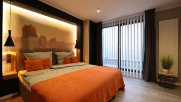 Un dormitorio moderno con una cama grande, un mural con vista a la ciudad en la pared, una ventana con persianas y una planta pequeña sobre una mesita de noche.