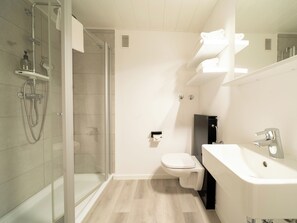 A modern bathroom with a glass-enclosed shower, a white toilet, and a large bathtub. - JustStay Mülheim/Oberhausen Hotel & Apartments (Muelheim an der Ruhr)