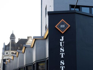 A building with a sign that reads "JUST STAY" and a dome structure in the background. - JustStay Mülheim/Oberhausen Hotel & Apartments (Muelheim an der Ruhr)