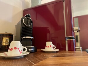 A coffee maker, two cups with red lipstick prints, and a red cabinet. - Boutique Apartment Vino e Amore (Freiburg im Breisgau)