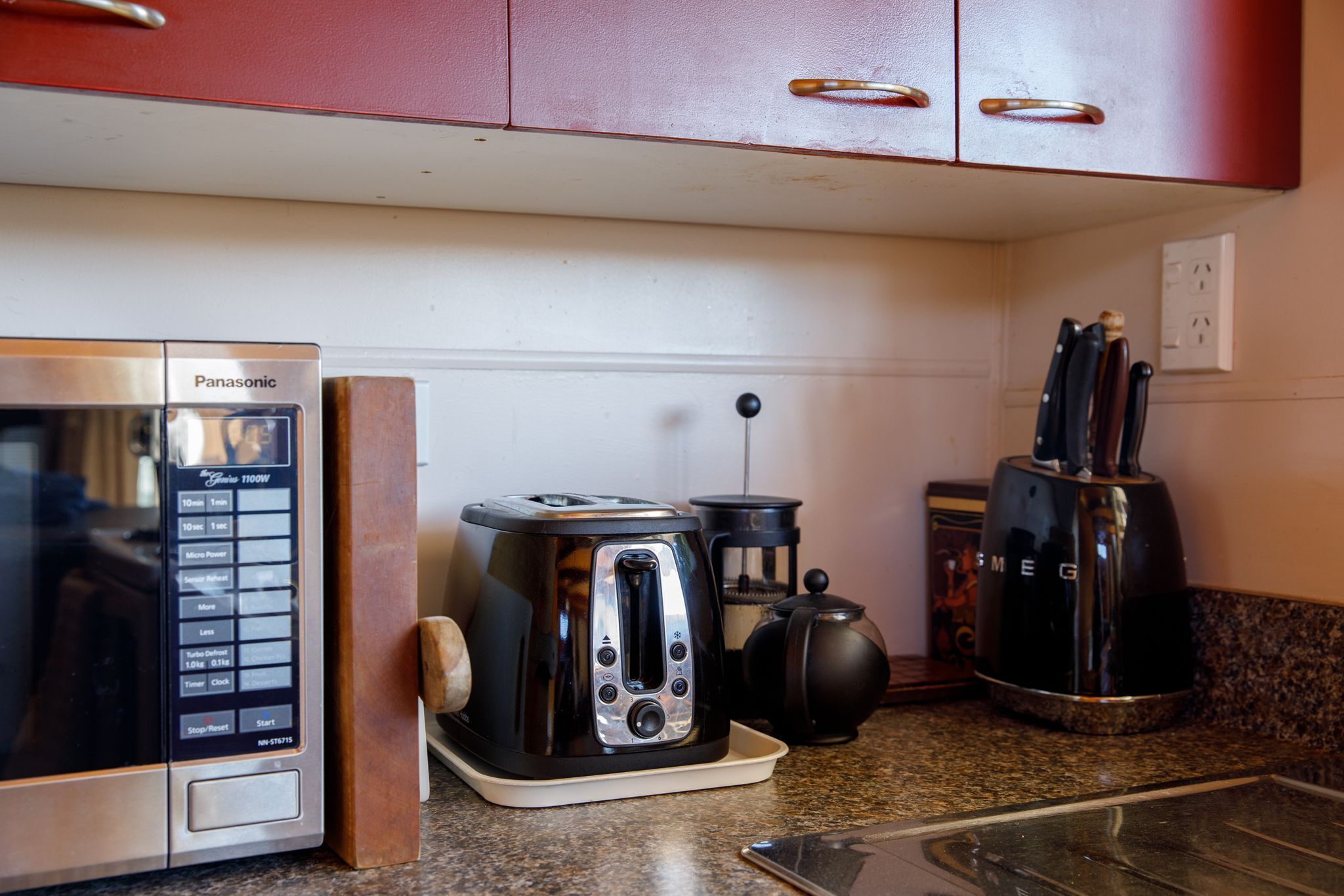 Une cuisine équipée d’un four à micro-ondes, d’un grille-pain et d’une machine à café, le tout posé sur le plan de travail.