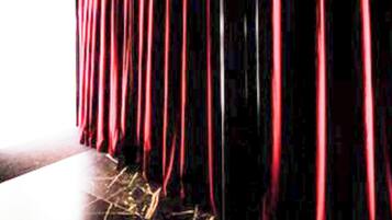A theater with red curtains and a stage.