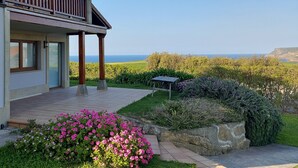 Una casa con balcón que ofrece vistas panorámicas del mar y los acantilados.
