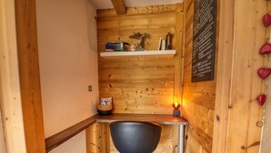A small room with a wooden interior, a desk with a chair, a shelf with books and decorative items, and a wall with a menu. - Quiet 2-bedroom apartment with terrace in Samoëns (Samoëns)