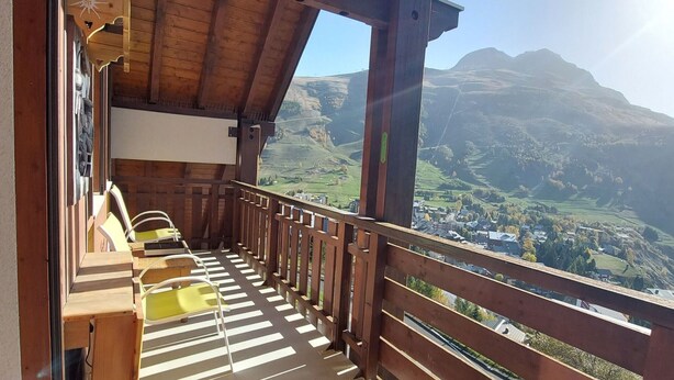 A wooden balcony with a view of a valley and mountains. - Charming T3 with view, close to slopes, pets allowed, covered parking (Les Deux Alpes)