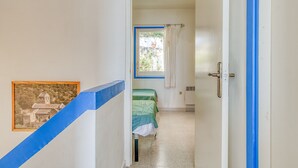A narrow hallway leading to a bedroom with a bed and a window. A framed picture is on the wall. - MALLORCA 15 Canyelles Roses (Rosas / Roses)