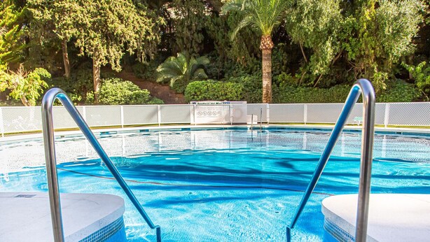 A swimming pool with clear blue water, surrounded by a tiled deck and metal handrails. - Luxurious penthouse in Marbella with pool, WiFi, pets allowed, air conditioning (Marbella)