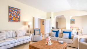 A living room with striped sofas, a wooden coffee table, and a painting on the wall. - Luxurious penthouse in Marbella with pool, WiFi, pets allowed, air conditioning (Marbella)