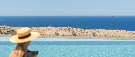 Ein Pool mit klarem, blauem Wasser, einer felsigen Küste und Blick auf den Ozean.