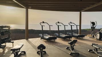 An outdoor gym with exercise equipment and a view of the sea.