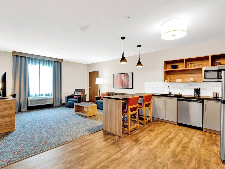 Una habitación de hotel moderna con cocina, comedor y sala de estar.