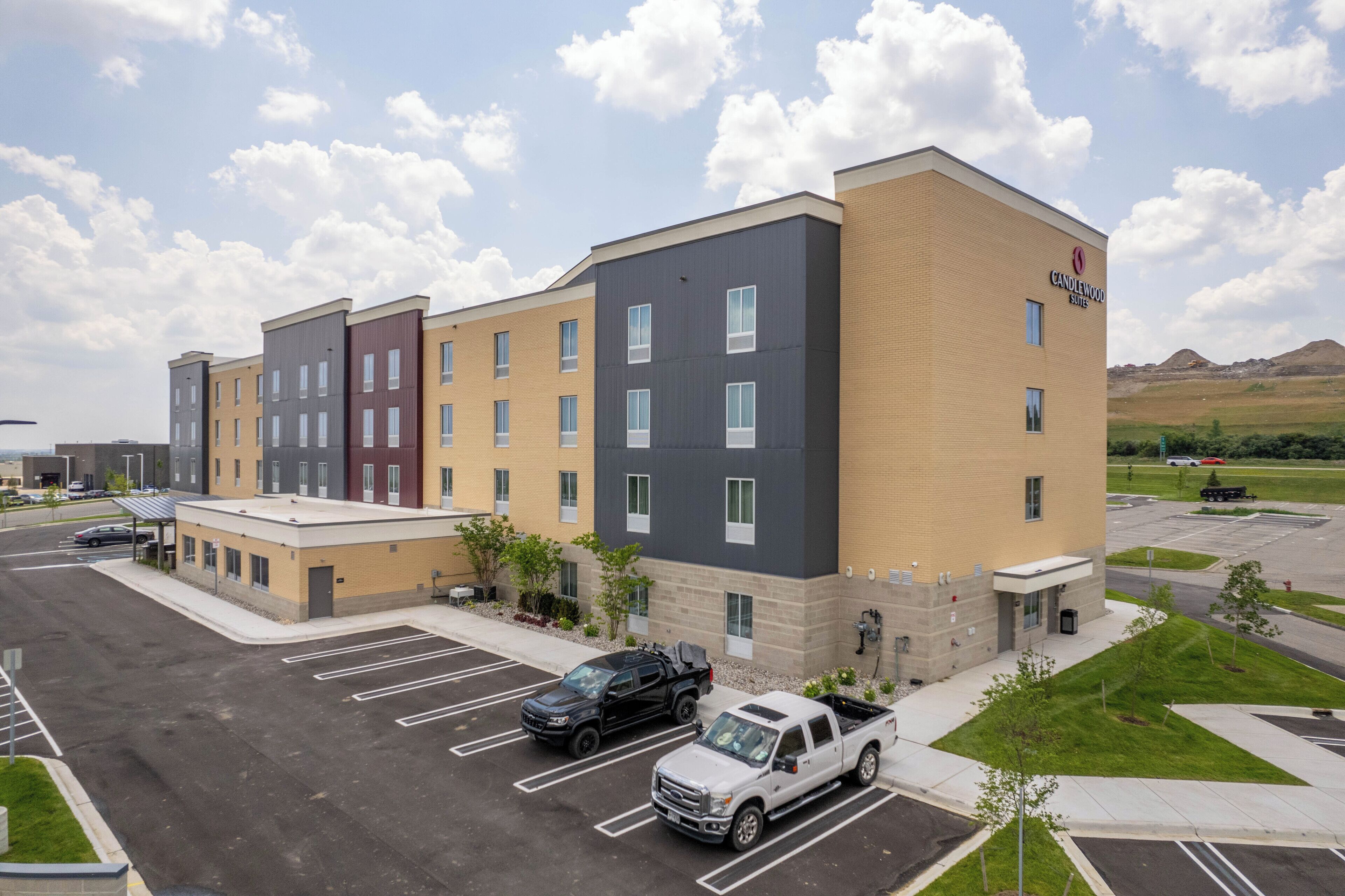 A multi-story hotel with a parking lot and a clear sky.