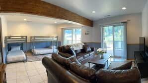 A living room with a sofa set, a coffee table, a TV, and bunk beds in the background. - ~Lakefront Property ~ 23 miles to Mt. Rainier! (Eatonville)