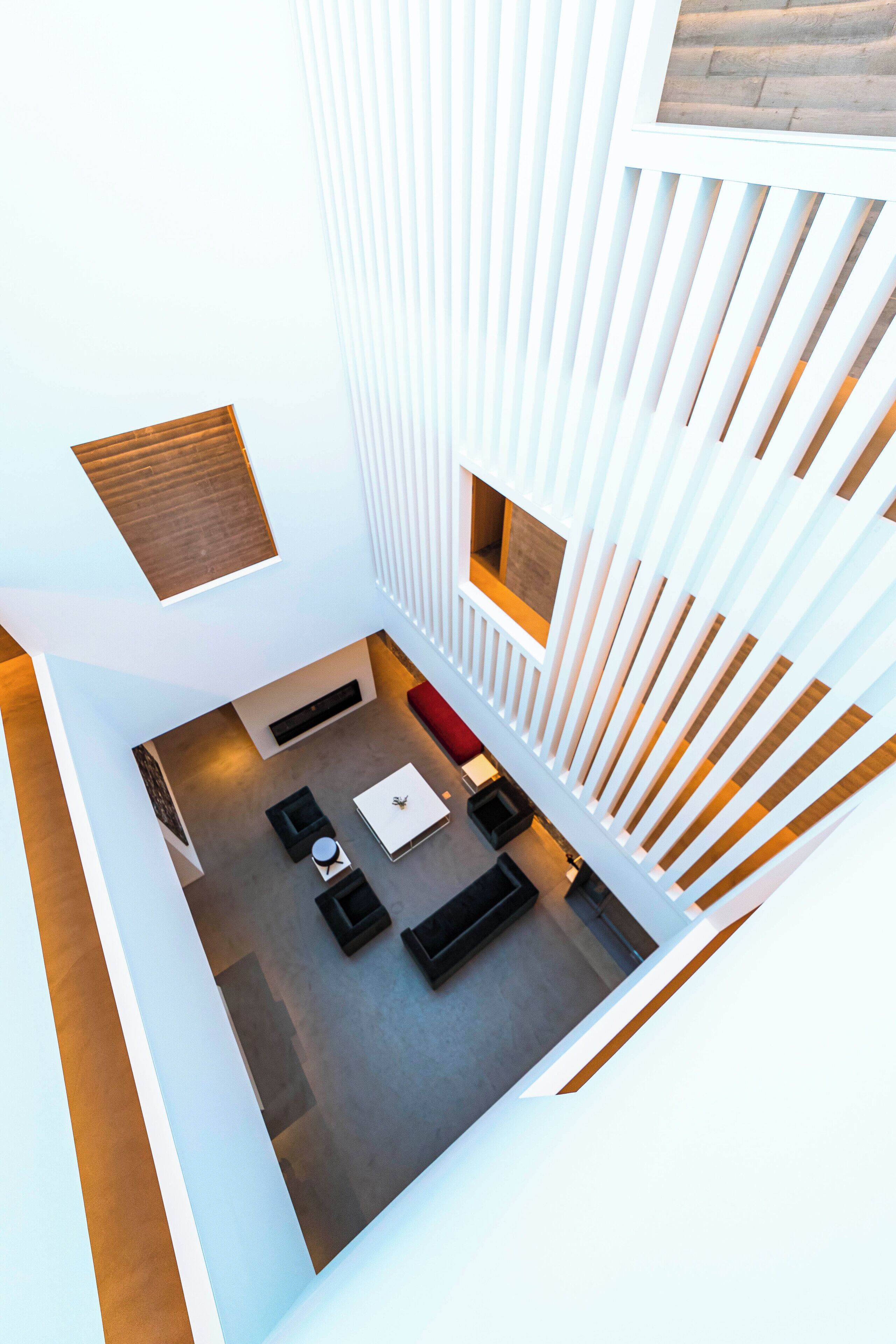 A modern interior with a central seating area, a small kitchen, and a view of the outdoors.