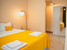 Una habitación de hotel con una cama, una mesita de noche, una lámpara y un espejo.