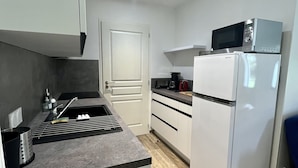A compact kitchen with a microwave, a refrigerator, and a sink. - House in a very quiet area (Saint-Georges-d'Oléron)