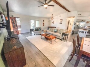 A spacious living area with a large sofa, coffee table, and dining table. There is a kitchen area with a refrigerator and cabinets. - 2nd floor, 2 bedroom, 2 bathroom unit near Boat Ramp 2 in Canyon Lake! (Canyon Lake)