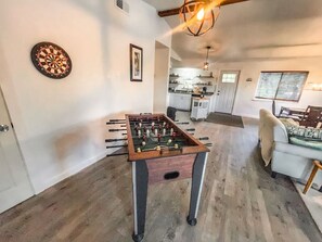 A room with a foosball table, a dartboard, and a kitchen in the background. - 2nd floor, 2 bedroom, 2 bathroom unit near Boat Ramp 2 in Canyon Lake! (Canyon Lake)