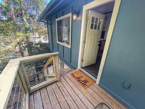 A wooden deck with a "hello" mat, a white door, and a window with a metal screen. - 2nd floor, 2 bedroom, 2 bathroom unit near Boat Ramp 2 in Canyon Lake! (Canyon Lake)