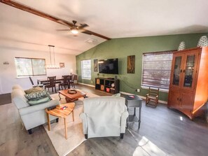 A spacious living room with a sofa, coffee table, TV, and wooden cabinet. - 2nd floor, 2 bedroom, 2 bathroom unit near Boat Ramp 2 in Canyon Lake! (Canyon Lake)