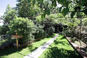 A pathway leading through a lush garden with a sign reading "PARCO RELLA". - a paradise in Tuscany closed to the sea, swimming pool gym and spa Bike friendly (Gavorrano)