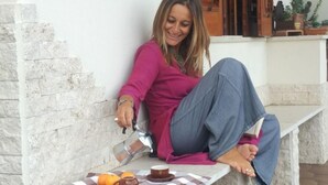 A person sitting on outdoor stone benches with a table in front of them, holding a cup and pouring a drink. - Villa Chorisia. Antique furniture Villa, large rooms and quiet area (Messina)