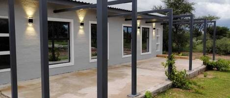 A modern building with a metal framework, large windows, and outdoor lighting.