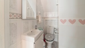 Un baño con lavabo, espejo, inodoro y azulejos decorativos.