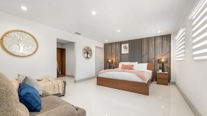 A modern bedroom with a large bed, a sofa, and a wall-mounted tree decoration. - Retreat Near MIA • Playground & Heated Pool, BBQ (Miami)