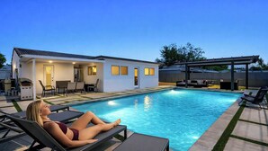 A poolside area with lounge chairs, a barbecue grill, and a covered patio. - Retreat Near MIA • Playground & Heated Pool, BBQ (Miami)