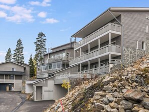 A multi-story building with balconies and a stone facade. - Holy rock by Interhome (Pelkosenniemi)