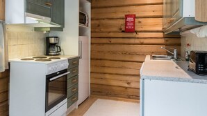 A compact kitchen with a stove, oven, microwave, and sink. - Kranni 2 by Interhome (Pudasjärvi)