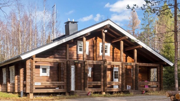 A log cabin with a porch, a chimney, and a gravel driveway. - Kranni 2 by Interhome (Pudasjärvi)