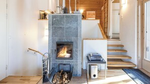Ein modernes Interieur mit Kamin aus Stein, einer Holztreppe und einem minimalistischen Design.