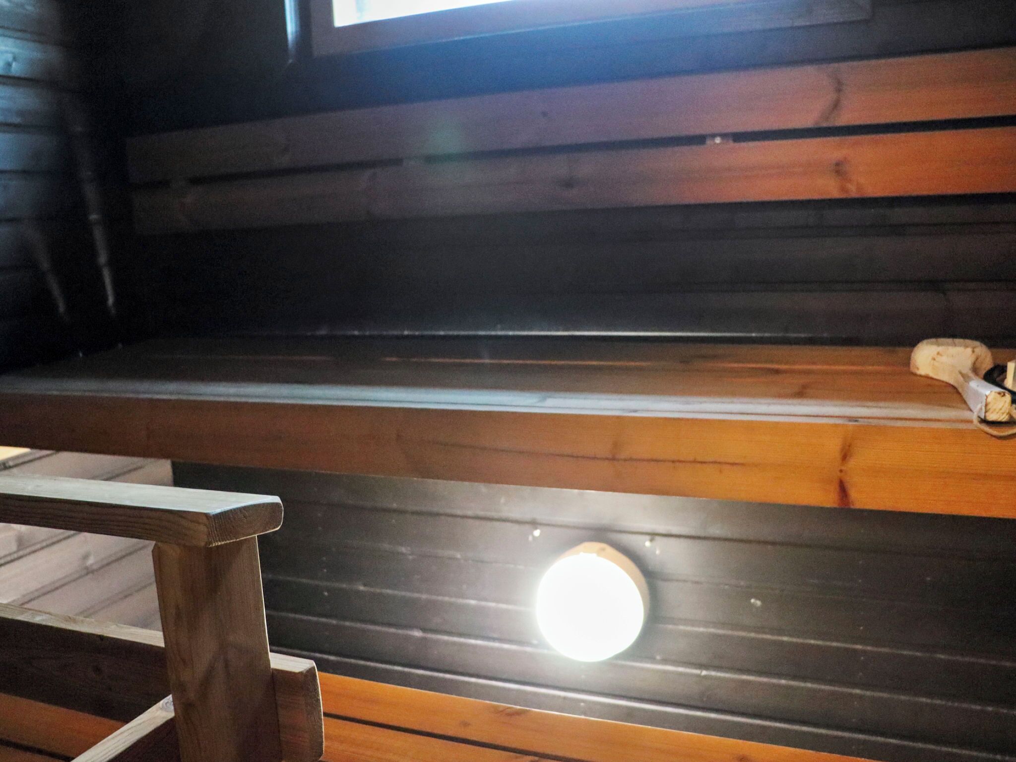 A wooden bench with a circular light fixture in the center.
