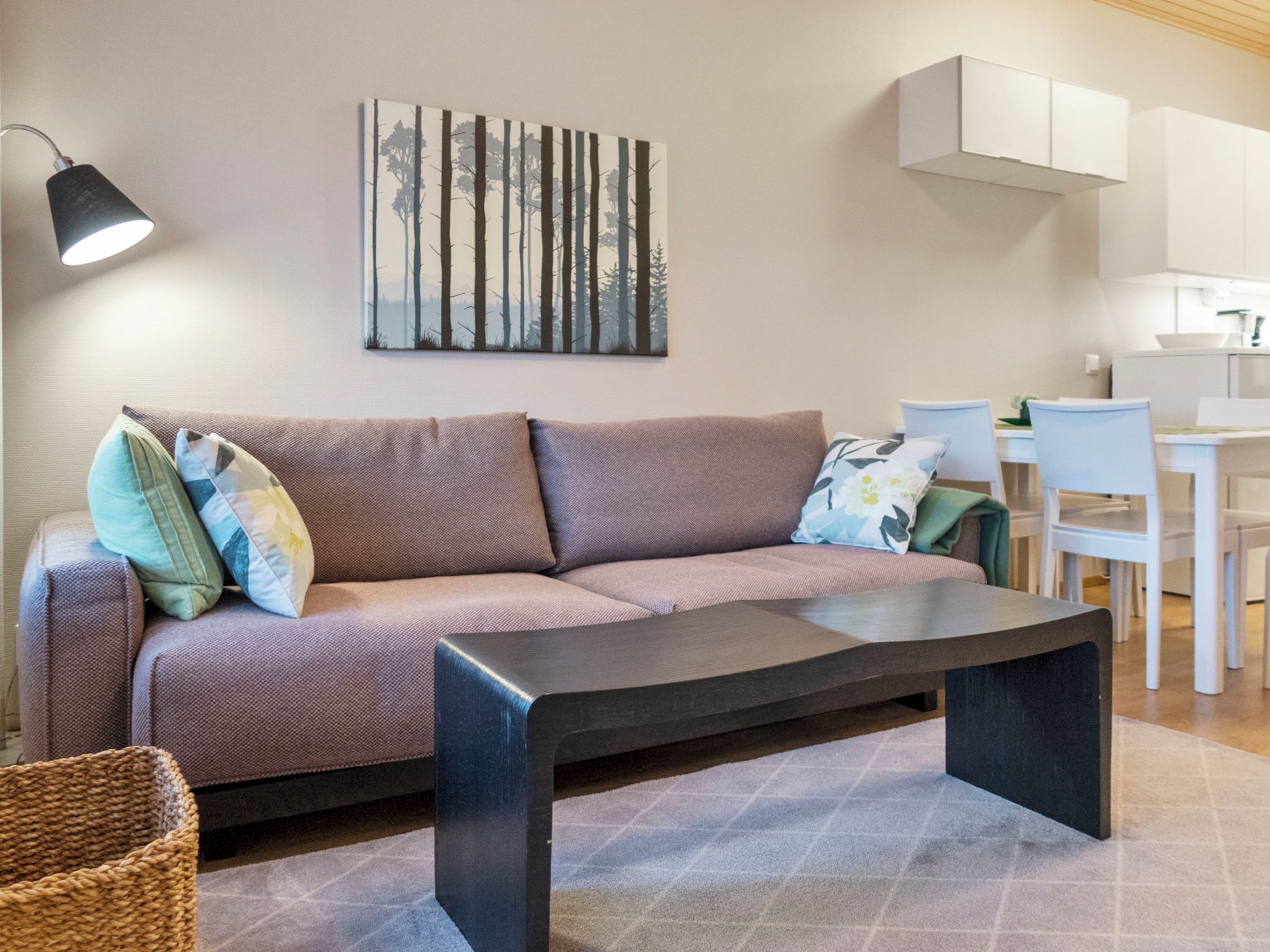 A modern living room with a sofa, a coffee table, and a painting on the wall.